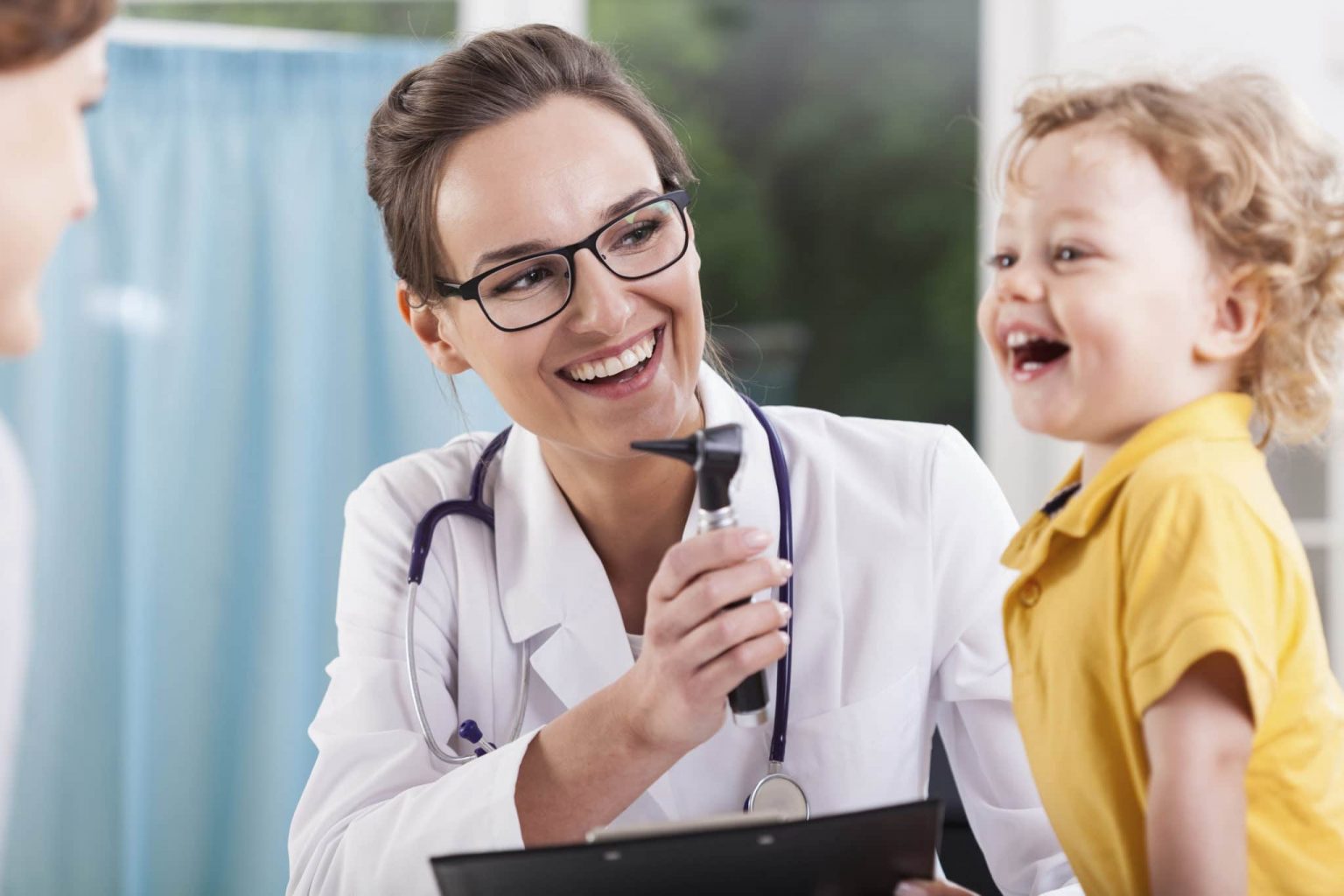 Happy audiologist and young patient discuss pediatric hearing loss.