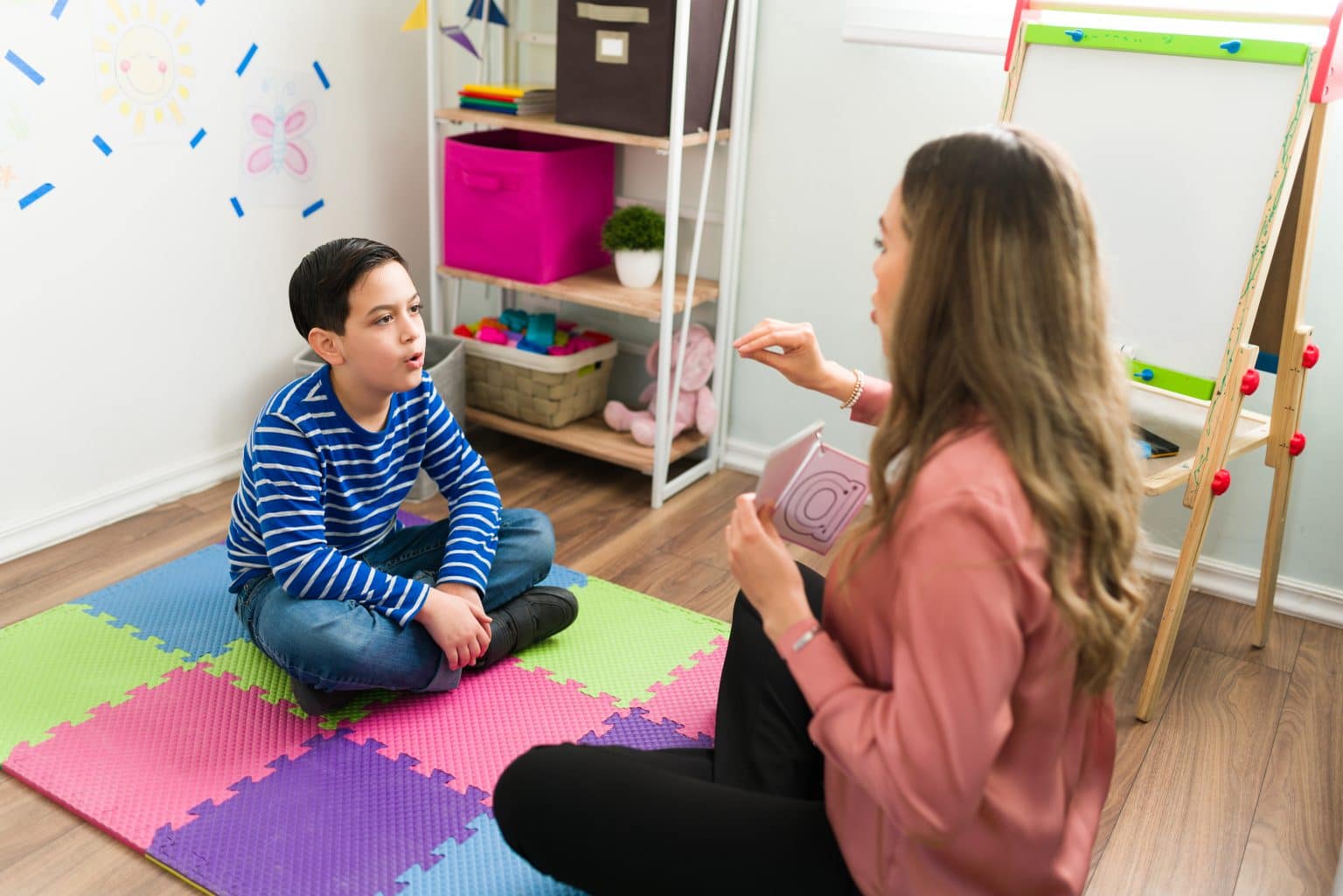 Speech pathologist helping a child through auditory verbal therapy